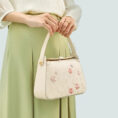 model-holding-plum-blossom-bag-both-hands-front